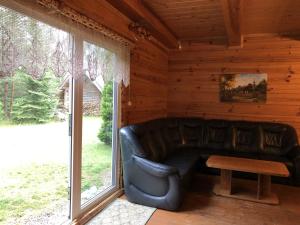 un sofá de cuero en una habitación con ventana en Pakaso sodyba, en Kirdeikiai