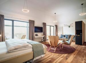 a bedroom with a bed and a living room at Romantik Hotel Hirschen in Parsberg