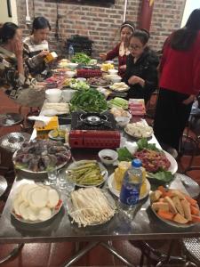 a group of people standing around a table full of food at Milk Milk Homestay in Yên Minh
