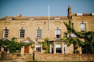 a large brick building with a flag on it at The Stratton House Hotel in Biggleswade