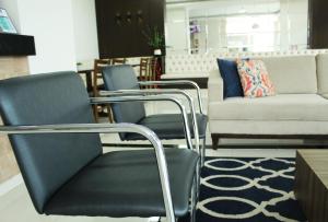 um grupo de cadeiras e um sofá numa loja em Mac Hotel em Palmas