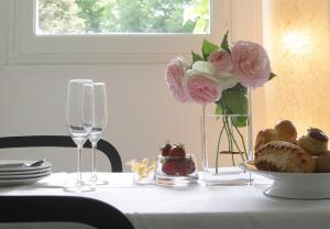 une table avec un vase de fleurs et une assiette de nourriture dans l'établissement Les Suites de Catherine, la Si Calme, à Nancy