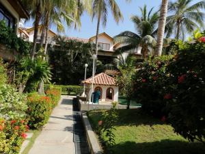um jardim em frente a um edifício com palmeiras em Casa, playa Bello Horizonte Santa Marta Colombia em Santa Marta