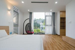 a white bedroom with a large bed and a swing at Flamingos Dai Lai Resort - Villa Tư Nhân có BBQ in Vĩnh Phúc +70 photos