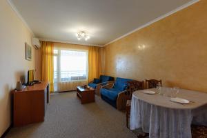 a living room with a table and a blue couch at Evridika Apartments in Nesebar