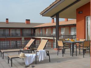 patio z krzesłami i stołem w budynku w obiekcie Hotel Isla de La Garena w mieście Alcalá de Henares