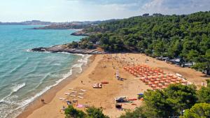 uma praia com um monte de pessoas e guarda-sóis em Villaggio Camping Punta Lunga em Vieste