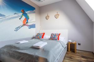 a bedroom with a bed with a painting of a skier at Apartamenty Rezydencja Karpielówka in Kościelisko