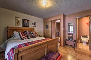 a bedroom with a wooden bed and a bathroom at Downtown Red River Retreat with Mtn Views and Yard in Red River