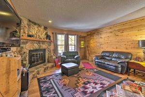 a living room with a leather couch and a fireplace at Downtown Red River Retreat with Mtn Views and Yard in Red River