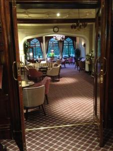 a living room filled with furniture and a large mirror at Oakwood Hall Hotel in Bingley