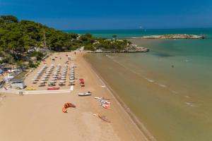 uma vista sobre uma praia com pessoas e guarda-sóis em Villaggio Capo Vieste em Vieste