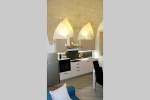 een keuken met witte kasten en een fornuis met oven bij Nel Cuore di Lecce in Lecce