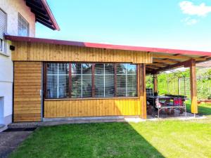 ein Holzhaus mit einer Terrasse und einem Tisch in der Unterkunft Haus Am Battenstein in Hilders