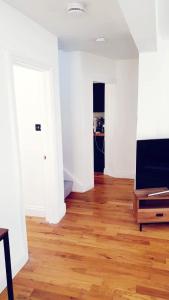 an empty room with a wooden floor and white walls at The Old Bank Beautiful Cotswold House with Huge Garden in Mickleton