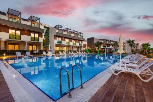een groot zwembad met witte ligstoelen voor een hotel bij Veranda Suites in Antalya