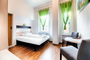 1 Schlafzimmer mit einem Bett, 2 Stühlen und einem Tisch in der Unterkunft Hotel B1 in Berlin