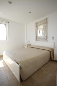 Un dormitorio con una cama con un espejo en la pared. en Tamarells 11, en Puerto Pollensa