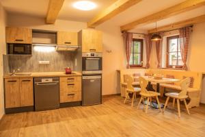 uma cozinha com uma mesa e cadeiras em Apartmány Kůlna em Boží Dar