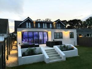 a house with a patio with a table in the yard at Corbiere in Shanklin