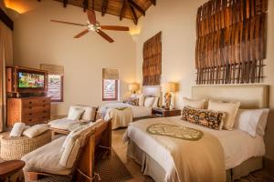 a bedroom with two beds and a ceiling fan at Mukul Resort in Tola
