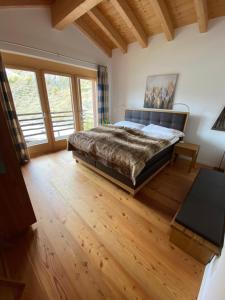 a bedroom with a large bed and wooden floors at Chalet Conthey in Zermatt