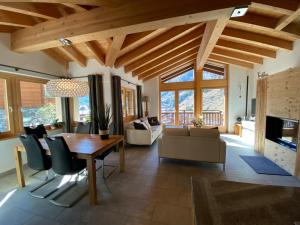 sala de estar con mesa de comedor de madera y sillas en Chalet Conthey en Zermatt