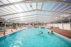 una piscina con persone in acqua di Camping Les Brillas a Les Moutiers