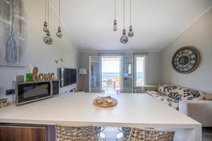 een keuken en woonkamer met een tafel en een bank bij Ilenia Seaview in Cefalù