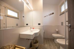 een witte badkamer met een wastafel en een toilet bij Ilenia Seaview in Cefalù +21 foto's