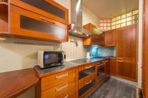 a kitchen with wooden cabinets and a microwave at Central Apartments on Khreschatyk in Kyiv