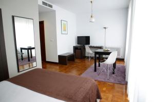 a bedroom with a bed and a table and a dining room at Hotel Mendez Nuñez in Lugo