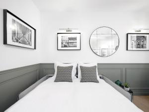 パリにあるLivinParis - Luxury 2 Bedrooms Opera Iのベッドルーム1室(大型ベッド1台、枕2つ、鏡付)