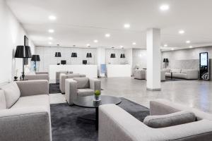 a lobby with couches and tables in a building at Eurostars Mar de Vigo in Vigo