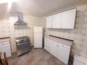 a kitchen with white cabinets and a stove top oven at Ampia Mansarda a Dimaro in Val di Sole in Monclassico