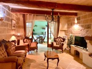 a living room filled with furniture and a fireplace at Classic Farmhouse & Private Pool in Mġarr