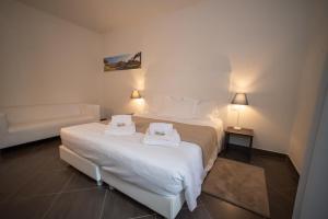 ein Hotelzimmer mit 2 Betten und einem Sofa in der Unterkunft CONDOMINIO I GELSI in Arezzo