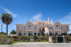 a large pink house with a palm tree at Joanne in Vale do Lobo