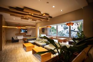 a living room with couches and tables and a large window at Hotel EcoSki by bund in San Carlos de Bariloche