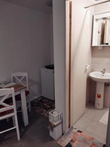 ein Badezimmer mit einem Waschbecken, einem WC und einem Tisch in der Unterkunft Studio Milica in Vrnjačka Banja
