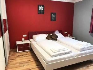 ツェル・アム・ゼーにあるHaus Schmitten – Austrian Alpine Getawaysの赤い壁のベッドルームにベッド2台が備わります。