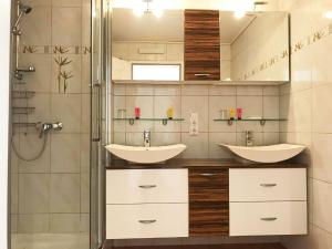 a bathroom with two sinks and a shower at Haus Schmitten – Austrian Alpine Getaways in Zell am See