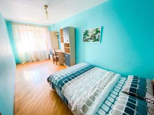 - une chambre bleue avec un lit et du parquet dans l'établissement ApartPoltava Затишна 3-кімнатна квартира в центрі міста, КАШТАНОВА АЛЕЯ, звітна документація, ЧЕК, à Poltava