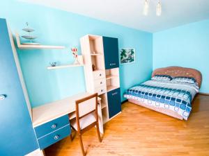 波爾塔瓦的住宿－ApartPoltava Затишна 3-кімнатна квартира в центрі міста, КАШТАНОВА АЛЕЯ, звітна документація, ЧЕК，一间卧室设有蓝色的墙壁、一张床和一张书桌