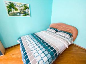 Ce lit se trouve dans un dortoir doté d'un mur bleu. dans l'établissement ApartPoltava Затишна 3-кімнатна квартира в центрі міста, КАШТАНОВА АЛЕЯ, звітна документація, ЧЕК, à Poltava