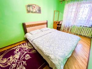 - une chambre avec un lit et un mur vert dans l'établissement ApartPoltava Затишна 3-кімнатна квартира в центрі міста, КАШТАНОВА АЛЕЯ, звітна документація, ЧЕК, à Poltava
