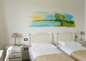皮切爾諾的住宿－Locanda Arcadia，一间卧室设有两张床,墙上挂着一幅画