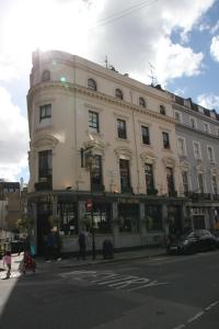 un gran edificio blanco en la esquina de una calle en Elysee Hyde Park, en Londres