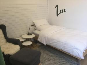 ein kleines Schlafzimmer mit einem Bett und einem Stuhl in der Unterkunft Ferienhaus Us lütt Hus und das Zimmer Linde im Haupthaus in Oldenburg