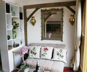 a living room with a couch and a mirror at Remarkable 1-Bed Cottage near Henley-on-Thames in Henley on Thames